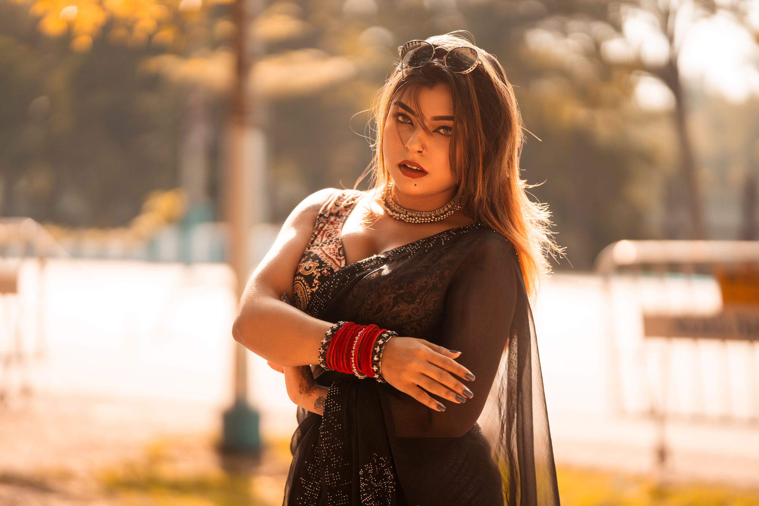Elegant outdoor portrait of a woman in traditional Indian dress with warm lighting.